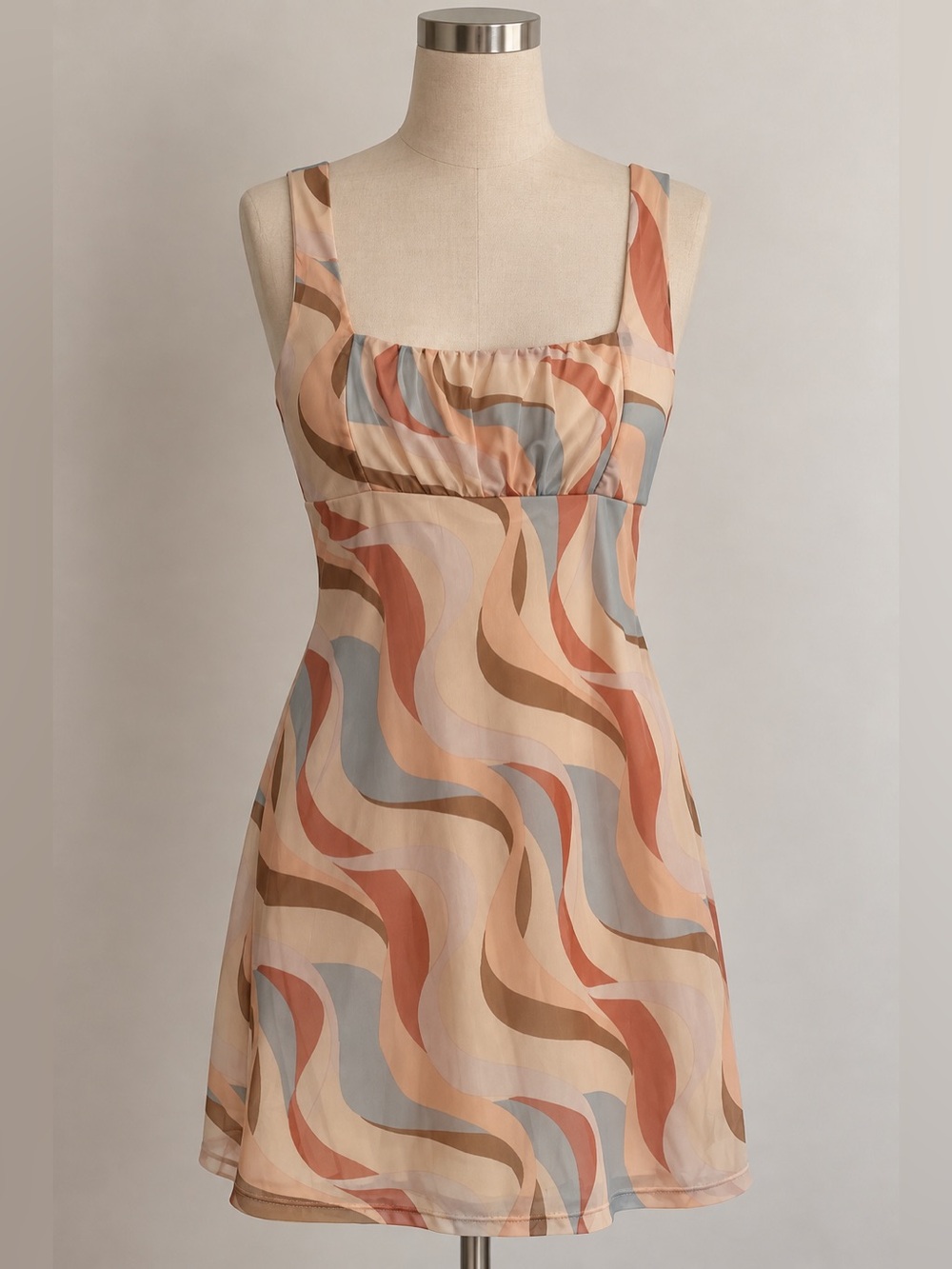 Retro swirl mini dress featuring a ruched bust and dreamy muted earth tones.